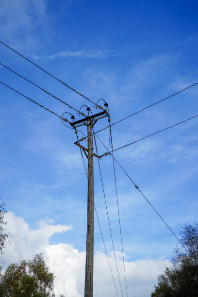 istock Looking up at power pylons with blue sky and clouds background 1429700098