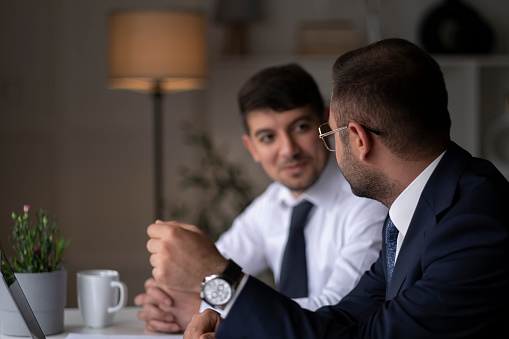 Two young businessmen discuss or plan project in office