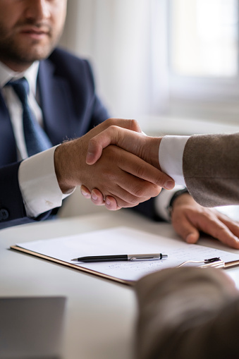 Estate agent shaking hands with his customer after contract signature