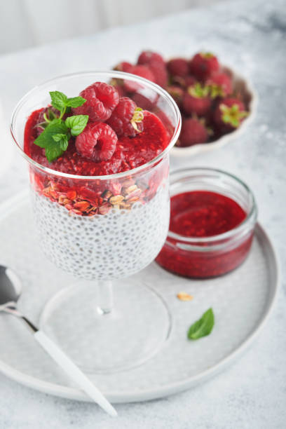 istock Chia pudding. Healthy vanilla chia pudding in glass with fresh raspberries and mint on white background. Vegan healthy breakfast. 1429704791