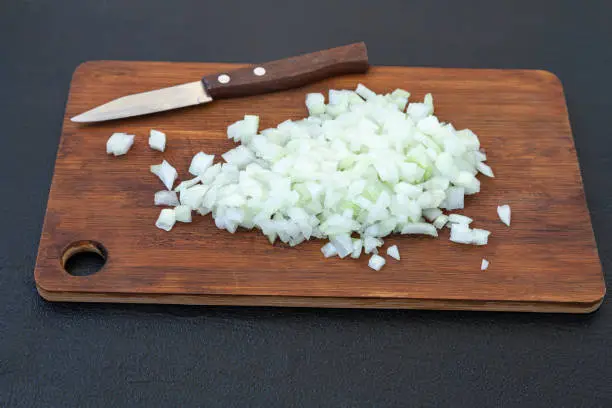 Chopped onion on a cutting board - preparation for cooking a dish with onions