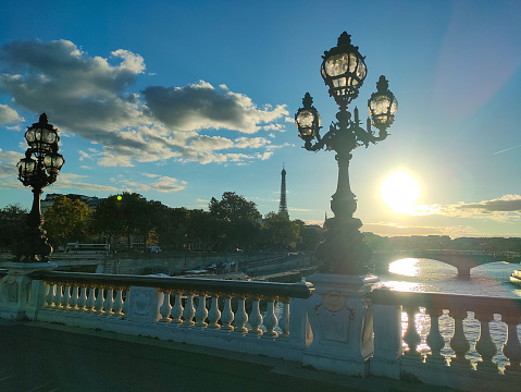Pont Alexandre III bridge over the River Seine and the Hotel des Invalides in the background in the sunny summer morning. Bridge decorated with ornate Art Nouveau lamps and sculptures. Paris, France