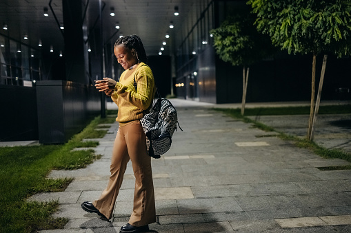 Young woman looking at the phone at night