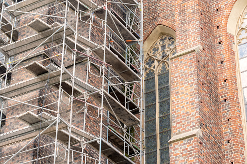Metal scaffolding near a gothic cathedral, church, old antique buildings renovation and restoration works in the city simple concept, landmarks, cultural heritage care and protection, nobody no people