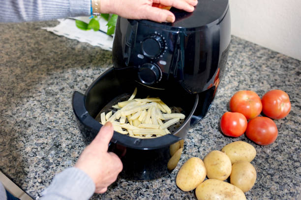 Air fryer Frying Sliced Potatoes in the Airfryer deep fryer stock pictures, royalty-free photos & images