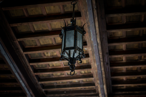 Dark grunge background with glowing lamp on the wall.