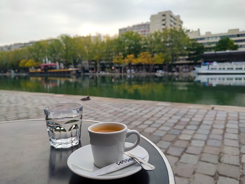 Street view of a sidewalk cafe with a coffee on the table in Paris