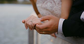 Hands, love and couple with diamond wedding ring shows trust, jewellery and support in a marriage commitment. People, jewelry and save the date event goals in engagement of bride and groom together