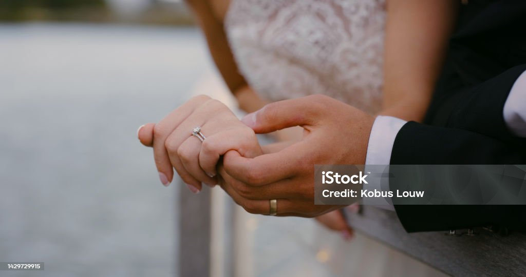 Hands, love and couple with diamond wedding ring shows trust, jewellery and support in a marriage commitment. People, jewelry and save the date event goals in engagement of bride and groom together Wedding Ring Stock Photo