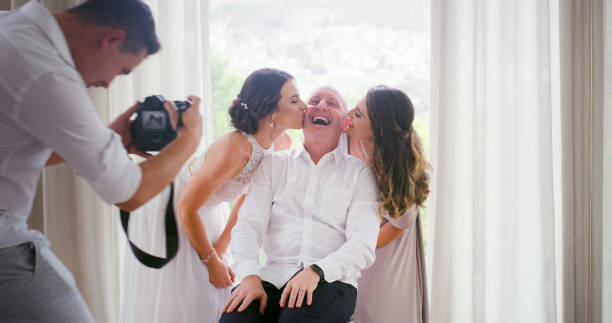 Family, wedding photographer and love for the father of the bride getting appreciation and kiss from his children for celebration photography. Laughing, happy and proud dad while daughter get married Family, wedding and photography with the father of the bride getting love, appreciation and kiss on cheek from his children on a big day. Laughing, happy and proud dad while daughter gets married bride hugging father on wedding day stock pictures, royalty-free photos & images