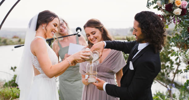 istock Happy couple at a wedding with a smile while doing sand union or ritual to symbol commitment and love in the relationship. Bride and groom at marriage event or reception  in nature during summer 1429730767