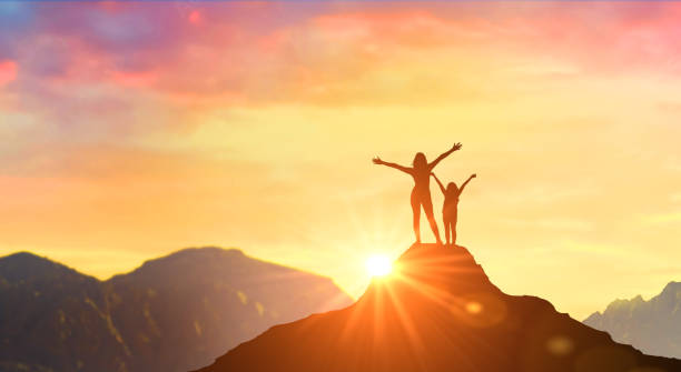 madre e hija se encuentran al amanecer en la cima de las montañas. mujer en la cima de la montaña con los brazos abiertos dando la bienvenida a un nuevo día con el amanecer. éxito, liderazgo, ganador en la cima. - mother superior fotografías e imágenes de stock