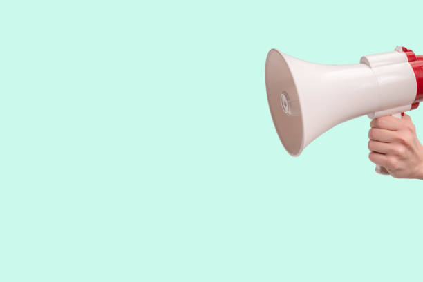 istock Megaphone in woman hands on a green background. 1429741469