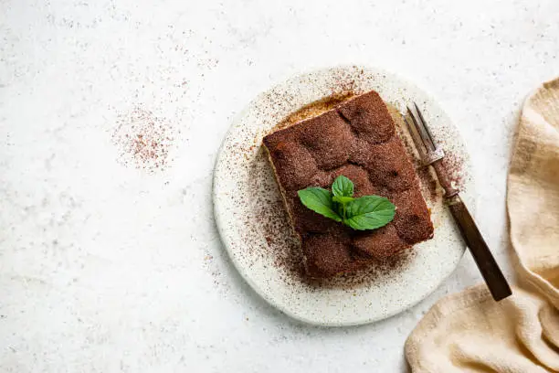 Piece of traditional Italian dessert tiramisu on white background, top view