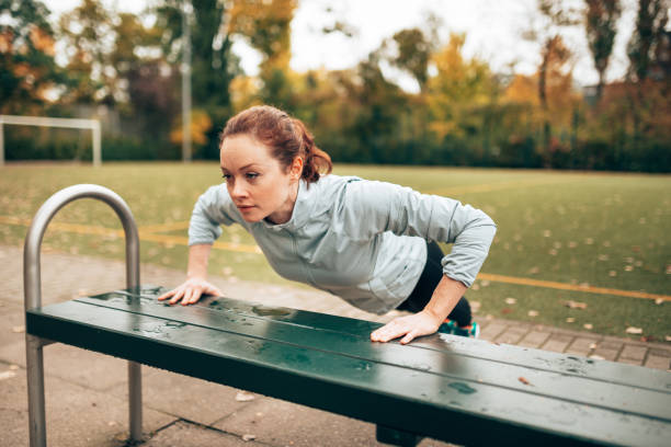 istock sportive woman doing pushups on the park 1429748557