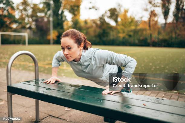 Sportive Woman Doing Pushups On The Park Stock Photo - Download Image Now - 20-24 Years, Active Lifestyle, Adult