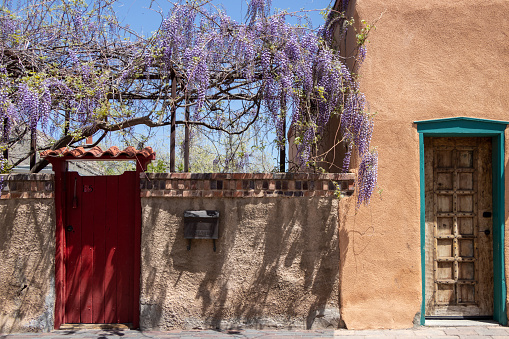 Wood turquoise colored door set in an old adobe wall in Santa Fe, New Mexico