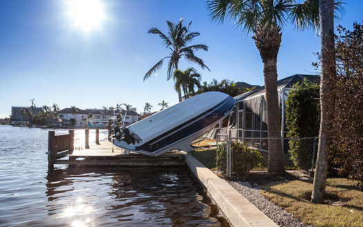 Naples, Florida, USA - September 28, 2022: NEWS  Flipped Boat pushed on land during Hurricane Ian storm surge flooding in Naples, Florida. Editorial only