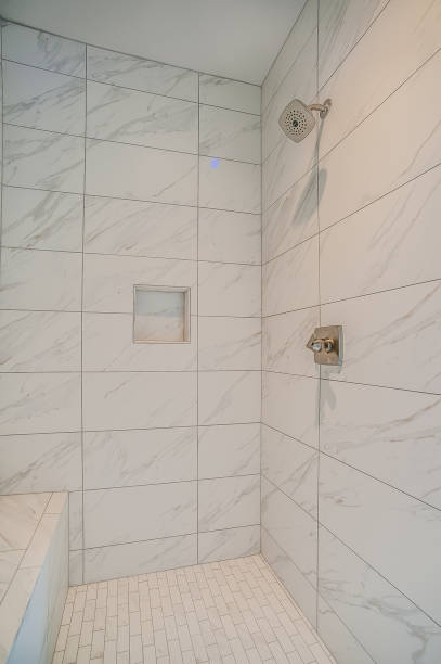 istock White tile shower with chrome shower head 1429770438