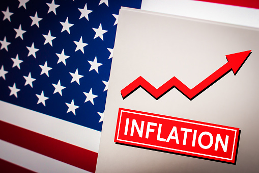 Conceptual keyword Inflation on card on US flag. Increase in the prices of goods or services and economic crisis concept. Business, economy, social concept of America.
