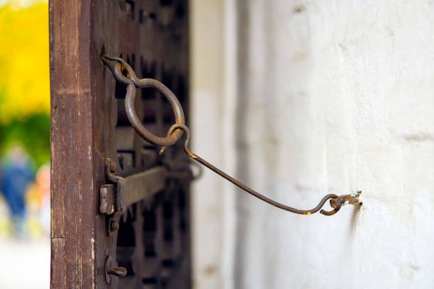 The old wooden gate sash with the bolt is kept open on the metall hook