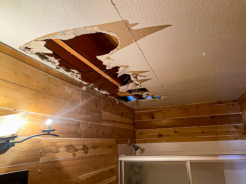Hole in ceiling after a water leak caused damage to the drywall