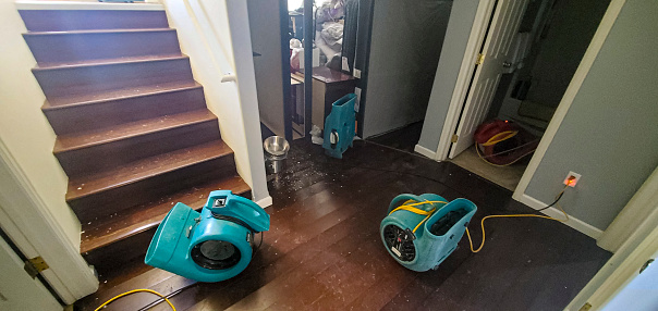 Air movers set in place to dry out a home after a water damage flood caused by a pipe break.