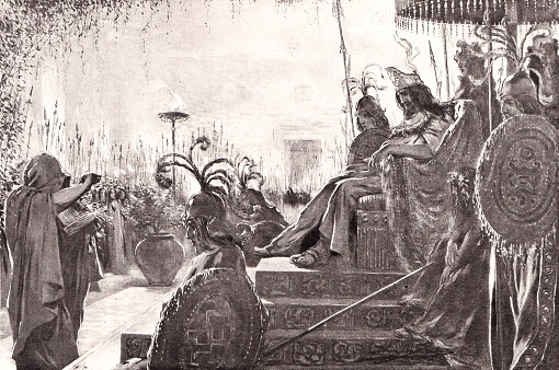 An Aztec priest advises the Chieftain (king) Montezuma II in 16th century Mexico. Illustration published in 1898. Source: Original edition is from my own archives. Copyright has expired and is in Public Domain.