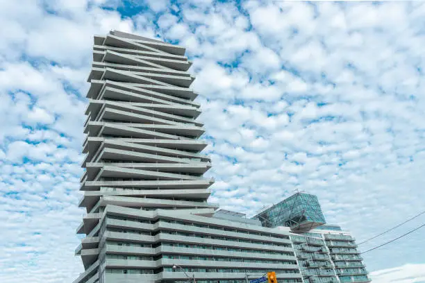 Photo of modern glass architecture buildings with Tower at Pier 27 building. Residential condos with crooked balconies