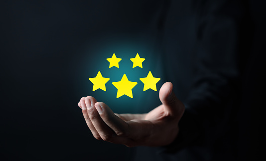 Businessman holding five stars for customer feedback and evaluation in experience service and product. Excellent rating. User give rating, good business network score.