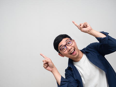 Young businessman cheerful gesture double point finger at copy space