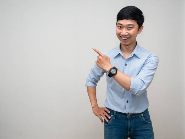 istock Cheerful man happy smile gesture point finger studio shot white background 1429834999