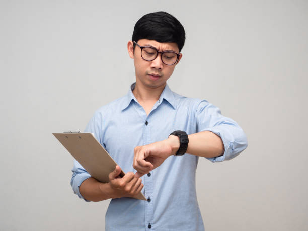 istock Businessman busy hold document board and looking at his watch isolated 1429838439