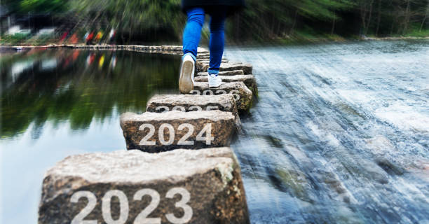 mulher cruzando degraus com número de ano novo 2023, 2024 e 2025 - stepping stone stone stepping footpath - fotografias e filmes do acervo