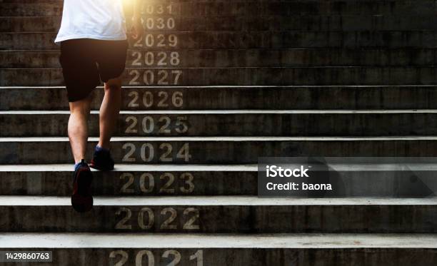 Man Running Up Outdoor Stairs With New Year Number 2022 2023 2024 To 2031 Stock Photo - Download Image Now