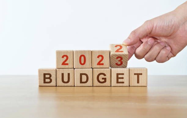 istock Man hand holding 2023 budget text on wooden blocks 1429861408