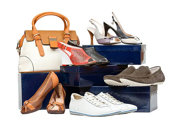 Shoes and handbag on boxes over white