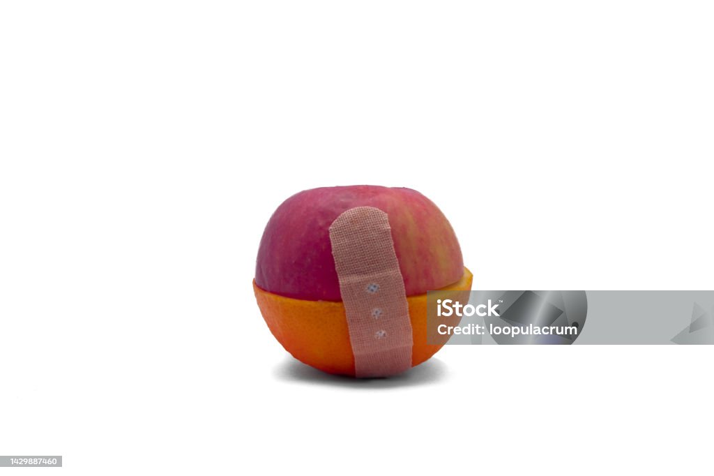 band aid holding half of orange and apple on white background with clipping path a close up of an edited half of apple and orange connecting with band aid with clipping path method to use it for every editing work Apple - Fruit Stock Photo