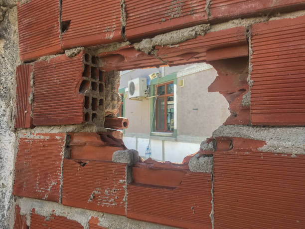 broken brick hole perspective seeing a window of another house a frame of brick hole and red bricks around islamic architecture stock pictures, royalty-free photos & images