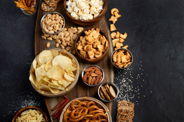 istock Assortment of salty snacks on dark background. 1429888392