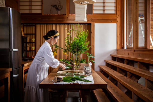 A woman cutting herbs and vegetables in the kitchen.