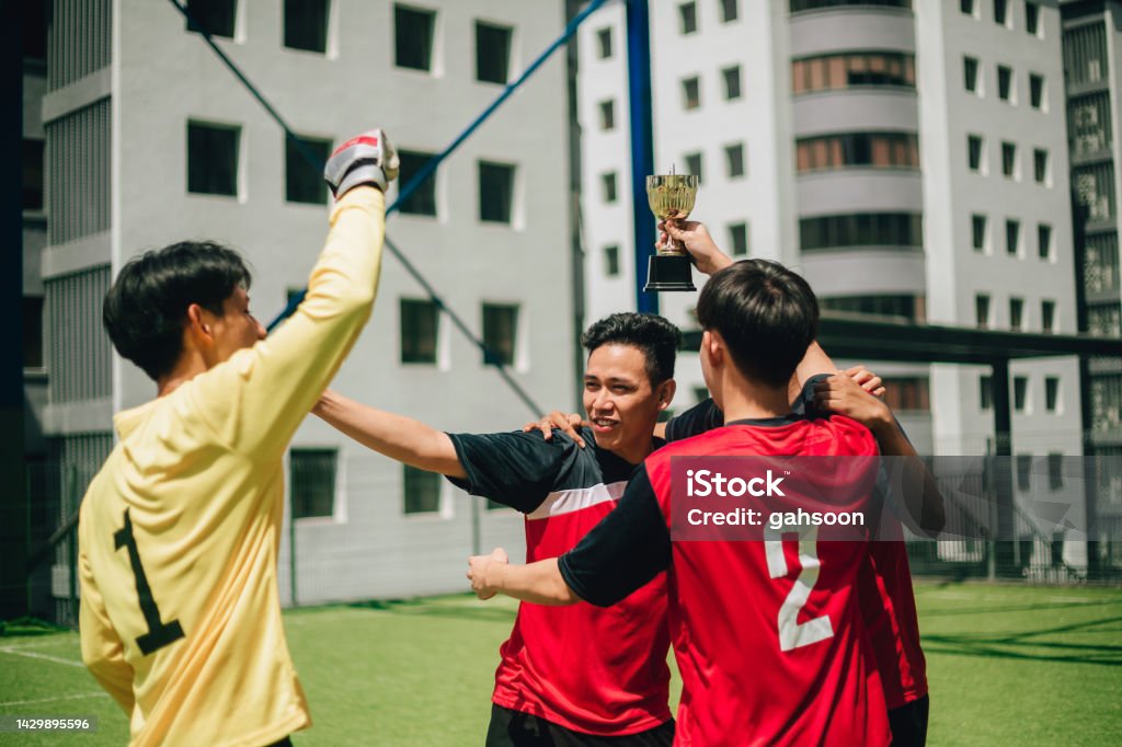 Football team won a trophy. happy moment of Soccer team celebrating wining moments, soccer competition winners, holding trophy. Asian and Indian Ethnicities Stock Photo