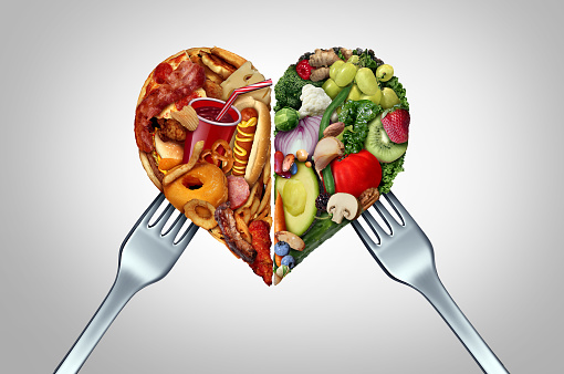 Unhealthy And Healthy Food Choice and diet decision concept or nutrition choices dilemma between good fresh fruit and vegetables with a dinner fork or junk food with high fat and sodium as divided love shaped as a heart with 3D illustration elements.