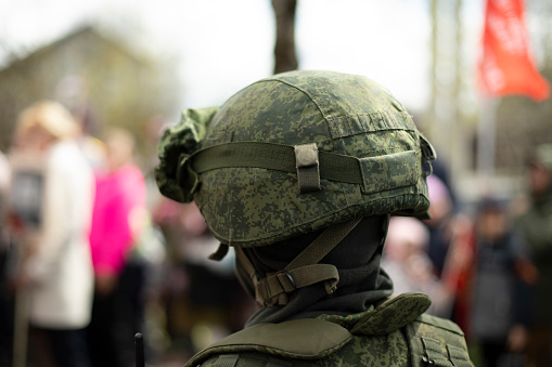 Helmet of Russian soldier. Military helmet on his head. Protective means against shot. Details of military ammunition.