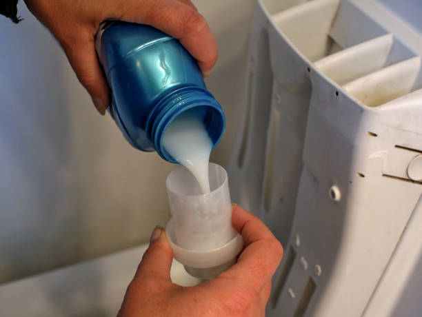 istock fabric softener is poured into a measuring cup near a washing machine. 1429909363