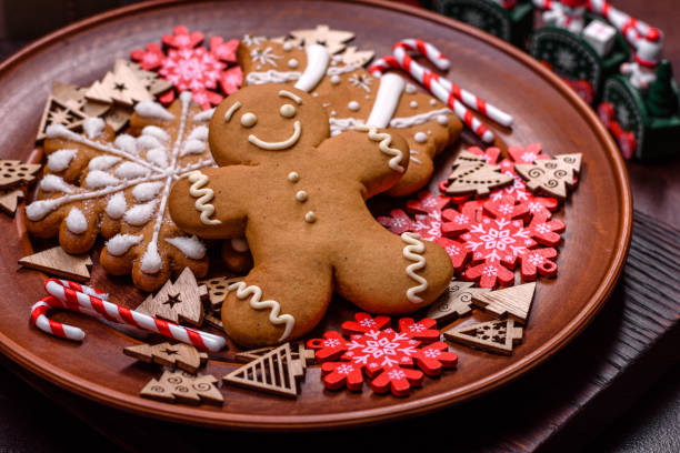 istock Beautiful gingerbread on a brown ceramic plate with Christmas tree decorations on a dark concrete background 1429913985