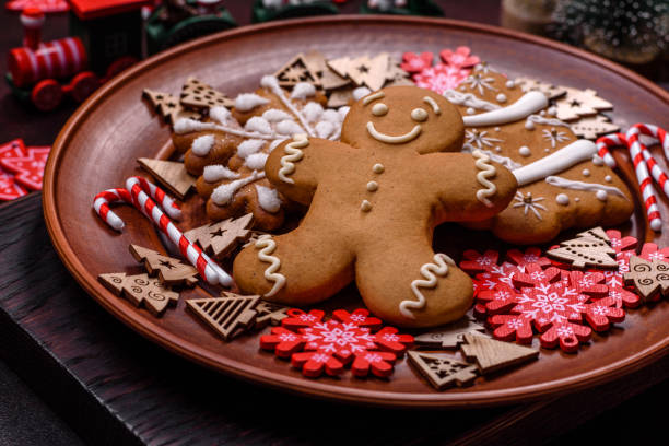 istock Beautiful gingerbread on a brown ceramic plate with Christmas tree decorations on a dark concrete background 1429913986