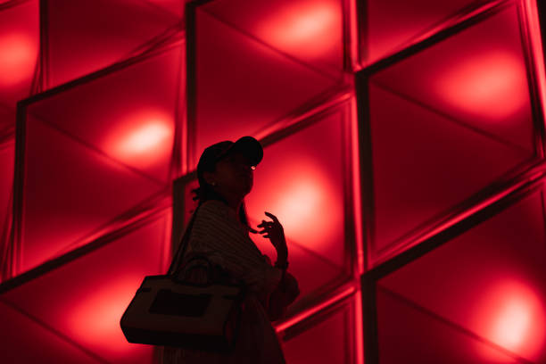 istock Lady silhouette on colorful lights background 1429914220