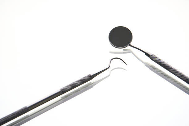 Dentist tools on white background with copy space. Dentist mirror a dental explorer curved, close-up
