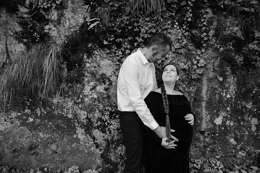 Cute and pregnant couple portrait looking at each other, black and white